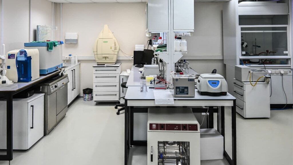 Especialista realizando mantenimiento preventivo y calibración de equipos de laboratorio en un centro de análisis en Lima, Perú